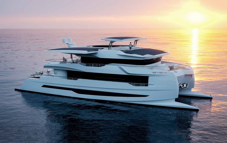 Modern catamaran on the water, at dusk with a brilliant sunset.
