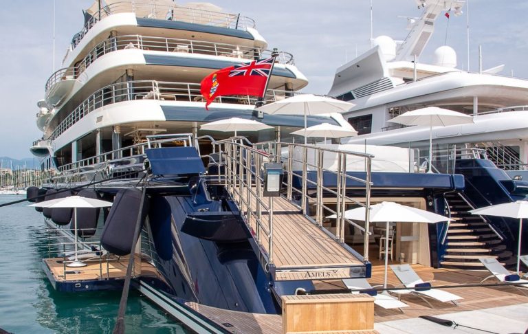 A luxurious moored yacht, with relaxation areas and a floating flag.