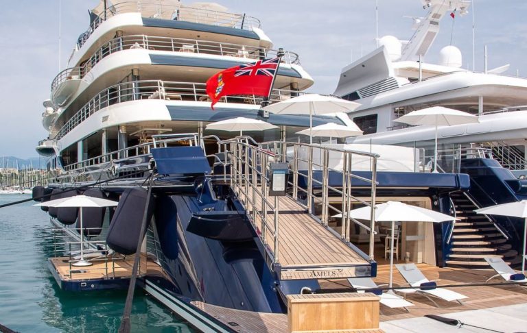 Luxurious yacht moored with ramp and flag.