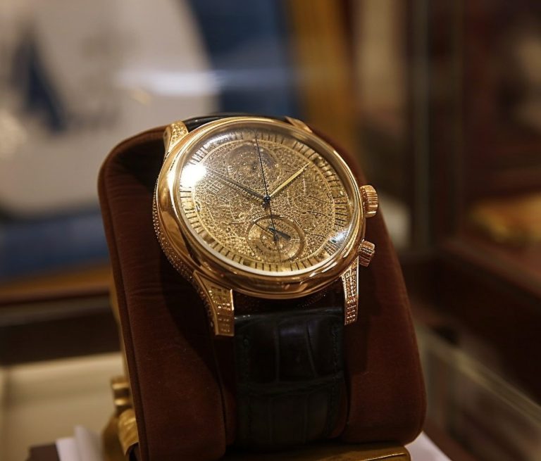 Pink gold watch with black leather strap, featuring a delicate and complex dial.