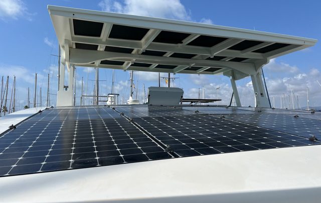 Solar panels on the roof of a boat, blue sky in the background.